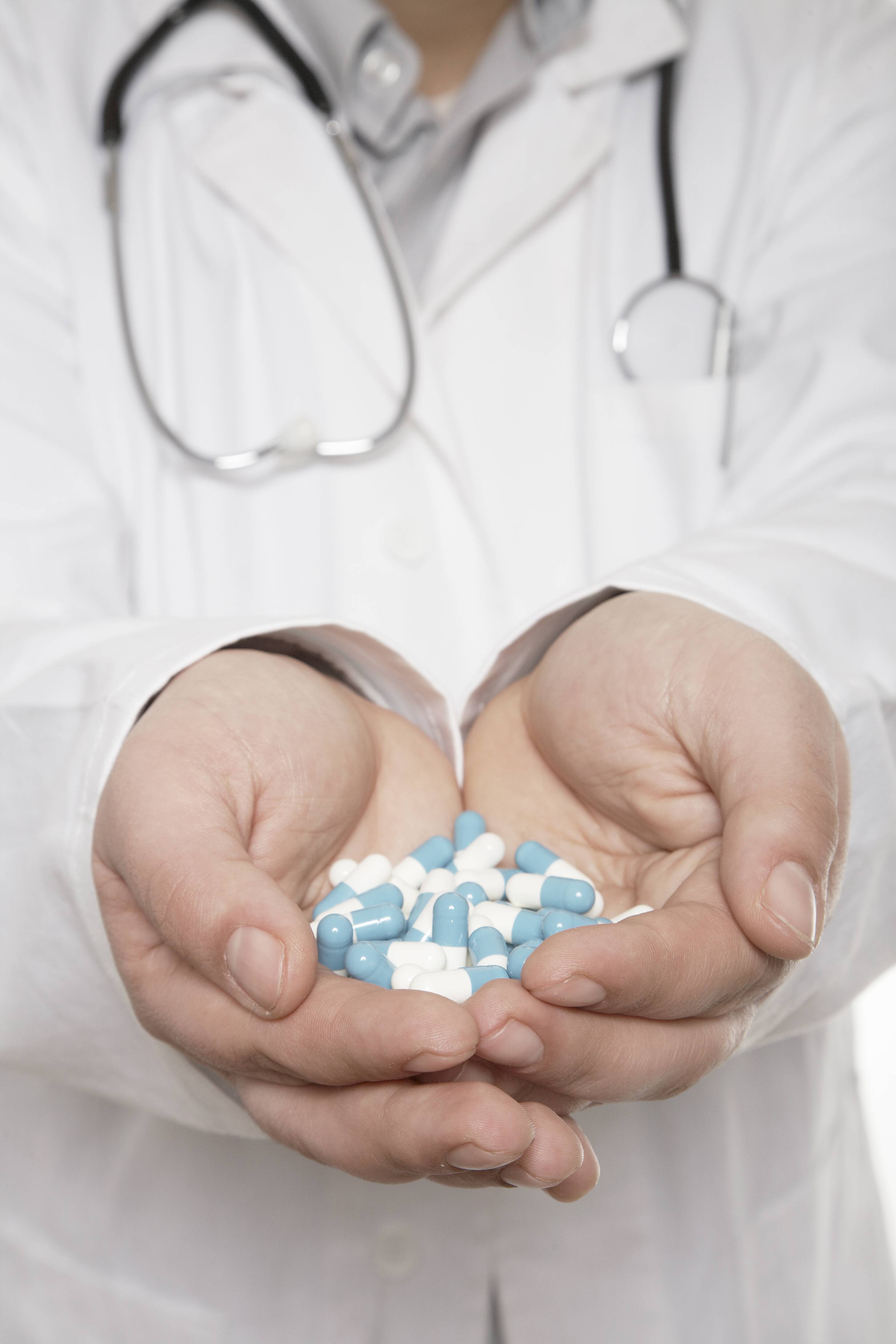 Arzt mit einer Hand voll Tabletten