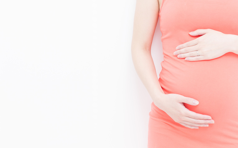 Schwangere Frau streichelt ihren Bauch