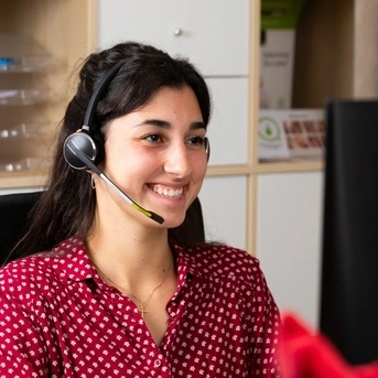 Mitarbeiterin Dorothee bei der Spenderbetreuung mit Headset am PC
