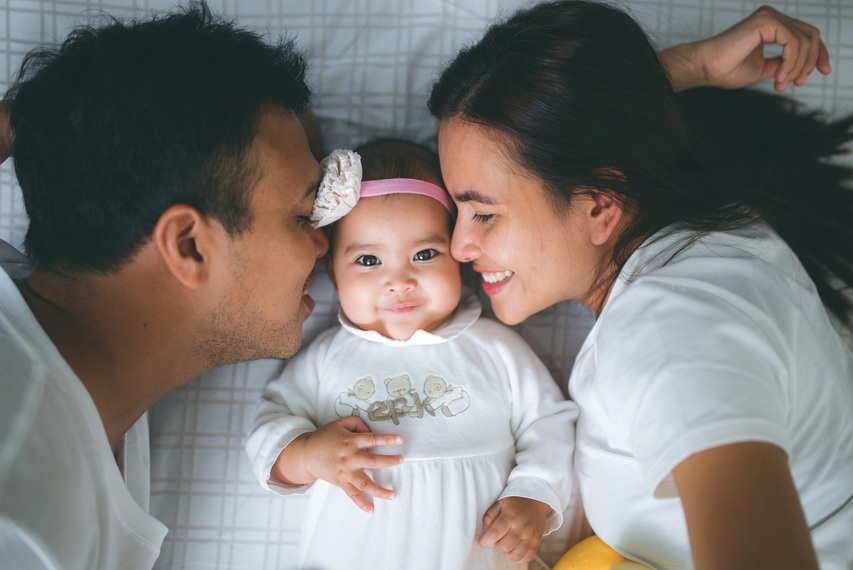 Parents kissing baby